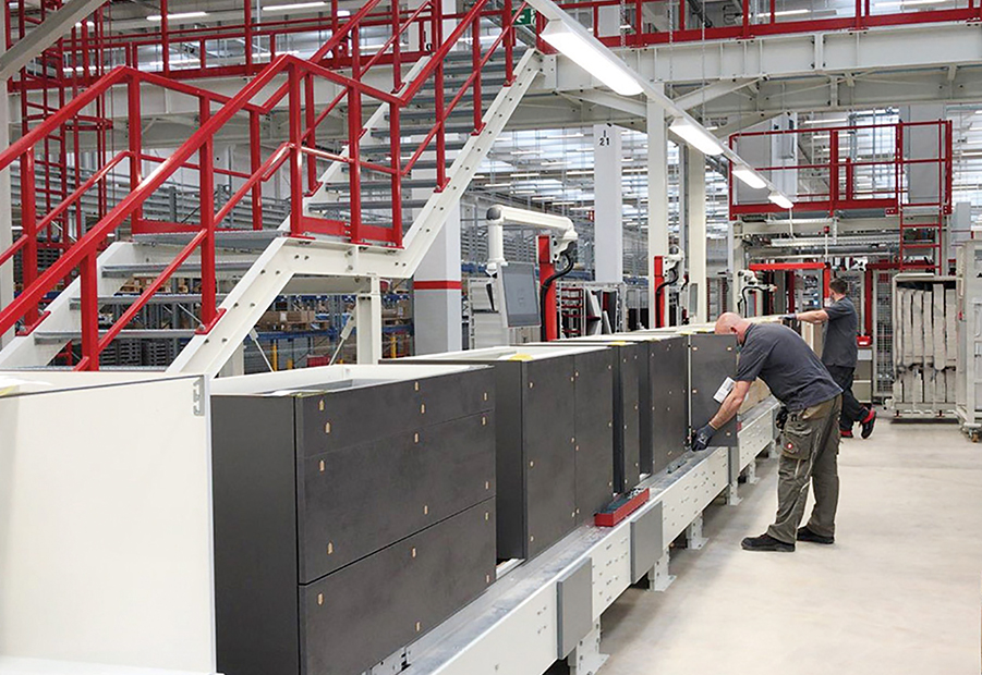 Ein Techniker inspiziert Maschinen in einer modernen Industrieanlage mit einem sauberen und organisierten Layout, das Präzision und Effizienz in der Fertigung betont.